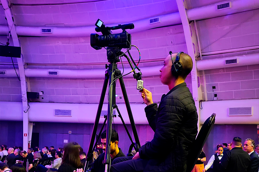 homem, sentado, operando uma câmera de vídeo, de uma produtora de vídeo em São Paulo